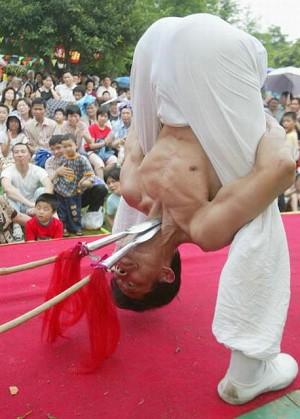Street performance of stabbing at the throat with spears. (Getty Images)