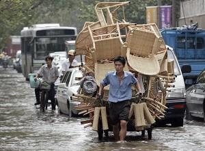 After a typhoon, a peddler pulls goods across the flooded area (Getty Images)