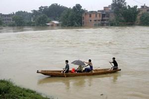 Residents of Fujian residents flee their home, steering their small boat through the flood, June 22, 2005. (Getty Images)