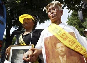 Korean family members of victims of World War II hold their relatives pictures during a march towards the Japanese embassy. (Chung Sung-Jun/Getty Images)