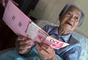 Hu Axiang, 88, receives her first pension at her home on September 28, 2006 in Shanghai, China. 26,788 residents over 70 years of age received their first pension checks after Chen Liangyu, secretary of the Shanghai Municipal Committee of Communist Party of China (CPC), was dismissed for graft involving the city's pension fund and a wide range of other corrupt practices. (China Photos/Getty Images)