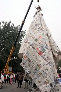 A crane helps display the full length of the newspaper dress. (The Epoch Times)