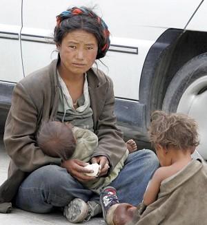 A poor woman breast-feeds her baby outside the Tashilhunpo Monastery in Shigatse, 06 August 2005 in southern Tibet. (Frederic J. Brown/AFP/Getty Images)