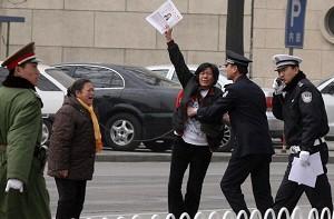 An appellant, waving an application for land compensation, is arrested by plainclothes and armed policemen in Tiananmen Square. (AFP/ Getty Image)
