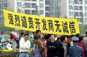Owners hang a banner that reads: "Strongly Condemn the Dishonest Real Estate Developer" to protest at the Shanghai Cannes Residential Area May 14, 2006 in Shanghai, China. (China Photos/Getty Images)