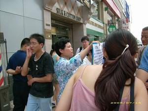 A tragedy of selling a daughter was put on show in the busy street of Beijing. (Feng Changle/The Epoch Times)