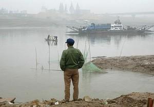 A farm worker, waiting for the ferry that would carry him across Dongting Lake, on October 31, 2004. (Frederic J Brown/AFP/Getty Images)