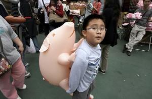 Hong Kong-A boy carries a pink pig-shaped balloon. (Mike Clarke/AFP Photo)