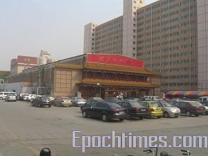 The curio shopping mall on the north side is located 30 meters away from Gao's home.  Judging by the vehicle number plates at least one third of the cars parked there belong to the police monitoring Gao's family. (The Epoch Times)