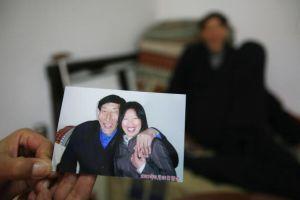 Bao Xishun shows pictures of his happy new life with wife, Xia Shujuan. (China Photos/Getty Images)