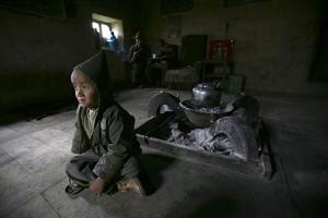 A Tibetan boy at home with Grandpa (Getty Images)