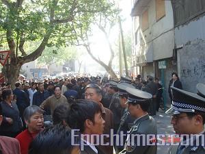 A crowd gathers to watch the forced eviction. (The Epoch Times)