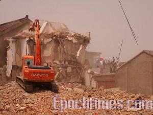 Workers using heavy machinery destroy homes and businesses. (The Epoch Times)