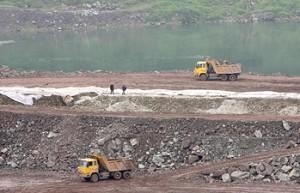 Two trucks dump earth on the construction of the Caojie hydropower station on Jialing River, a tributary of the Yangtze river, where water levels remain near historic lows, in Chongqing, China. (Liu Jin/AFP/Getty Images)