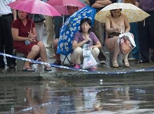 Parents wait in the rain for their children to write exams