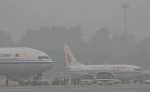Passengers board an Air China plane as haze blankets the international Airport in Beijing. (Teh Eng Koon/AFP/Getty Images)