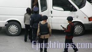 Plainclothes military police grasping onto their submachine guns. (Han Xinxin/The Epoch Times)