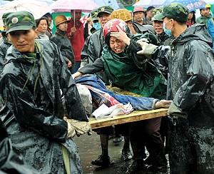 A mother screams in grief as Chinese soldiers carry away the body of her child, who was killed when a school collapsed during the 7.8 magnitude earthquake in Dujiangyan, in southwest China Sichuan province, May 13, 2008. (Teh Eng Koon/AFP/Getty Images)