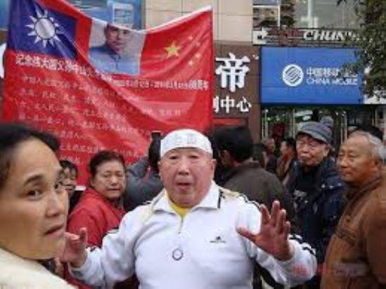 Han Liang in Chongqing, China. A poster behind him depicts the Nationalist and communist Chinese flags as well as republican Chinese leader Sun Yat-sen. (Boxun)