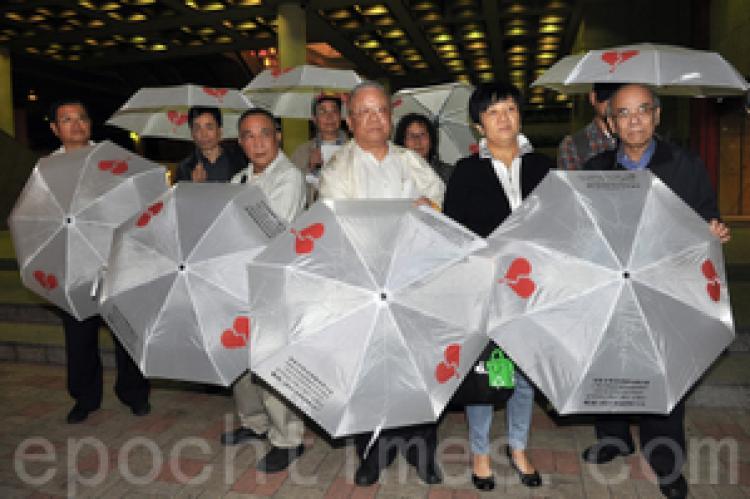 <a><img src="https://www.theepochtimes.com/assets/uploads/2015/09/1011131229571366--ss.jpg" alt="Nine members of the Hong Kong (China) Investment Rights Concern Group each carrying an umbrella with symbol and info of the group. (Kwong Tianming/Epoch Times)" title="Nine members of the Hong Kong (China) Investment Rights Concern Group each carrying an umbrella with symbol and info of the group. (Kwong Tianming/Epoch Times)" width="320" class="size-medium wp-image-1812127"/></a>