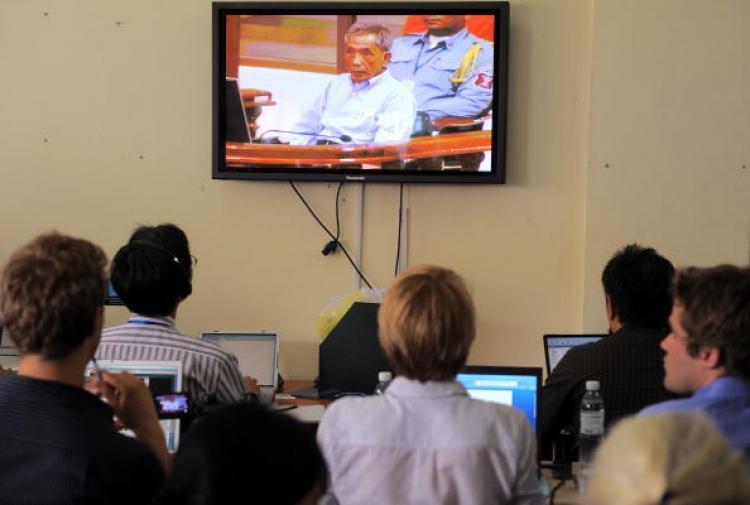 <a><img src="https://www.theepochtimes.com/assets/uploads/2015/09/103086788.jpg" alt="Local and international journalists look at a live video in a press room at the Extraordinary Chamber in the Courts of Cambodia in Phnom Penh on July 26, showing former Khmer Rouge also known as Duch, during the reading of the verdict in his trial for all his crimes. (Tang Chin Sothy/Getty Images)" title="Local and international journalists look at a live video in a press room at the Extraordinary Chamber in the Courts of Cambodia in Phnom Penh on July 26, showing former Khmer Rouge also known as Duch, during the reading of the verdict in his trial for all his crimes. (Tang Chin Sothy/Getty Images)" width="320" class="size-medium wp-image-1817016"/></a>