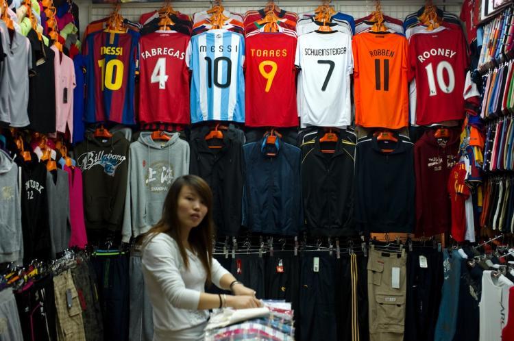 <a><img src="https://www.theepochtimes.com/assets/uploads/2015/09/103809860.jpg" alt="A Chinese shopkeeper arranges clothes next to fake FIFA football jerseys at a stall in a market that sells a lot of counterfeit merchandise in Shanghai on Sept. 3. Many experts are now questioning the United States's actions--or lack thereof--in combating patent infringements. (Philippe Lopez/Getty Images)" title="A Chinese shopkeeper arranges clothes next to fake FIFA football jerseys at a stall in a market that sells a lot of counterfeit merchandise in Shanghai on Sept. 3. Many experts are now questioning the United States's actions--or lack thereof--in combating patent infringements. (Philippe Lopez/Getty Images)" width="320" class="size-medium wp-image-1813859"/></a>