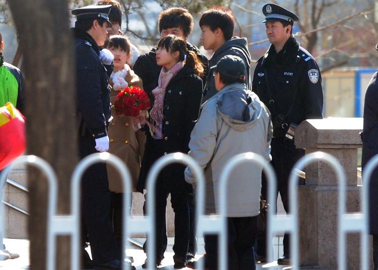 <a><img src="https://www.theepochtimes.com/assets/uploads/2015/09/109804712.jpg" alt="A woman carrying a bouquet of flowers is questioned by policemen on patrol near the Xidan shopping district in Beiijng on March 6, amid heightened security with the ruling Communist Party's annual parliament underway.  (AFP/Getty Images)" title="A woman carrying a bouquet of flowers is questioned by policemen on patrol near the Xidan shopping district in Beiijng on March 6, amid heightened security with the ruling Communist Party's annual parliament underway.  (AFP/Getty Images)" width="320" class="size-medium wp-image-1807088"/></a>