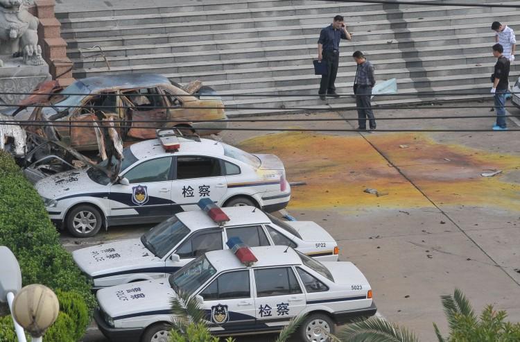 <a><img src="https://www.theepochtimes.com/assets/uploads/2015/09/114726633bomb.jpg" alt="Officials stand beside damaged cars at a government office after an explosion occured in Fuzhou city, in east China's Jiangxi Province on May 26, 2011. (AFP/Getty Images)" title="Officials stand beside damaged cars at a government office after an explosion occured in Fuzhou city, in east China's Jiangxi Province on May 26, 2011. (AFP/Getty Images)" width="320" class="size-medium wp-image-1802641"/></a>