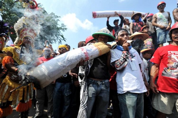 <a><img src="https://www.theepochtimes.com/assets/uploads/2015/09/118962666.jpg" alt="Indonesian tobacco farmers protest in Jakarta on July 13, 2011 against a new law which would ban cigarette advertising and sponsorship, prohibit smoking in public and add graphic images to packaging. Around 30 percent of Indonesians above the age of 10 smoke an average of 12 cigarettes a day, according to a 2008 report. And cigarettes are cheap at less than a dollar a pack. According to the World Health Organisation, smoking rates have risen six-fold in Indonesia over the last 40 years. Smoking kills at least 400,000 people every year and another 25,000 die from passive smoking. ( Adek Berry/AFP/Getty Images)" title="Indonesian tobacco farmers protest in Jakarta on July 13, 2011 against a new law which would ban cigarette advertising and sponsorship, prohibit smoking in public and add graphic images to packaging. Around 30 percent of Indonesians above the age of 10 smoke an average of 12 cigarettes a day, according to a 2008 report. And cigarettes are cheap at less than a dollar a pack. According to the World Health Organisation, smoking rates have risen six-fold in Indonesia over the last 40 years. Smoking kills at least 400,000 people every year and another 25,000 die from passive smoking. ( Adek Berry/AFP/Getty Images)" width="320" class="size-medium wp-image-1800641"/></a>