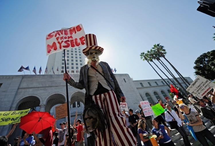 <a><img src="https://www.theepochtimes.com/assets/uploads/2015/09/127824391ii.jpg" alt="Protesters hold signs after a march to Los Angeles City Hall during the Occupy Los Angeles demonstration in solidarity with the ongoing Occupy Wall Street protest in New York City on October 1, 2011 in Los Angeles, California. (Kevork Djansezian/Getty Images)" title="Protesters hold signs after a march to Los Angeles City Hall during the Occupy Los Angeles demonstration in solidarity with the ongoing Occupy Wall Street protest in New York City on October 1, 2011 in Los Angeles, California. (Kevork Djansezian/Getty Images)" width="575" class="size-medium wp-image-1796401"/></a>