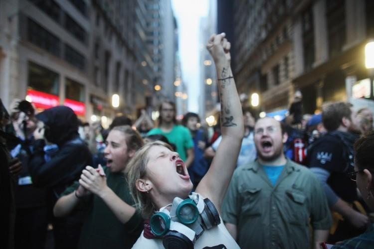<a><img src="https://www.theepochtimes.com/assets/uploads/2015/09/129216985ii.jpg" alt="Demonstrators associated with the Occupy Wall Street movement face off with police in the streets of the financial district after the deadline for their removal from Zuccotti park was postponed on October 14, 2011 in New York City. (Spencer Platt/Getty Images)" title="Demonstrators associated with the Occupy Wall Street movement face off with police in the streets of the financial district after the deadline for their removal from Zuccotti park was postponed on October 14, 2011 in New York City. (Spencer Platt/Getty Images)" width="575" class="size-medium wp-image-1796393"/></a>