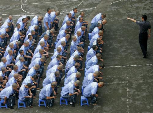 Inmates listen to a police officer during a behavior training session at Chongqing Prison on May 30, 2005. (China Photos/Getty Images)