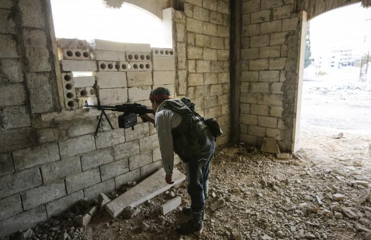 <a><img class="size-large wp-image-1773926" src="https://www.theepochtimes.com/assets/uploads/2015/09/156592258.jpg" alt="A rebel machine gunner watches Syrian army positions around 2,000 feet away in the town of Maaret Al-Numan, on Nov. 17, 2012. (John Cantlie/AFP/Getty Images)" width="590" height="381"/></a>