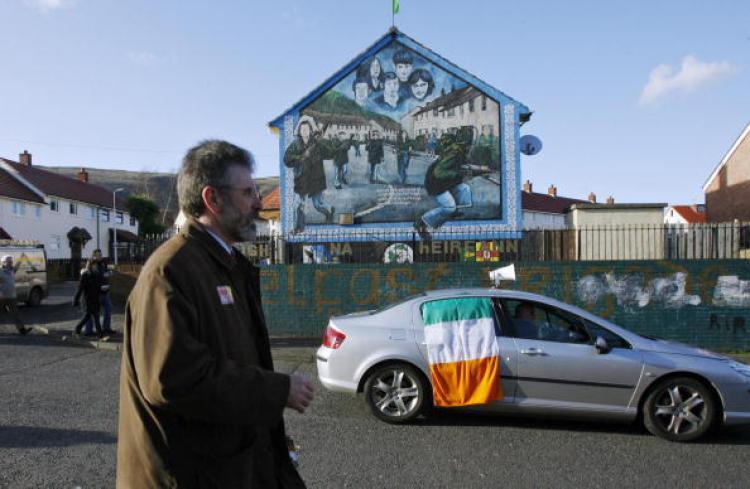 <a><img src="https://www.theepochtimes.com/assets/uploads/2015/09/73507410.jpg" alt="Sinn Fein leader Gerry Adams (L), MP for Ballymurphy, walks past a republican mural in the Ballymurphy area of West Belfast, Northern Ireland, canvasing for votes on 06 March 2007. (AFP PHOTO/Peter MUHLY/Getty Images)" title="Sinn Fein leader Gerry Adams (L), MP for Ballymurphy, walks past a republican mural in the Ballymurphy area of West Belfast, Northern Ireland, canvasing for votes on 06 March 2007. (AFP PHOTO/Peter MUHLY/Getty Images)" width="320" class="size-medium wp-image-1817991"/></a>