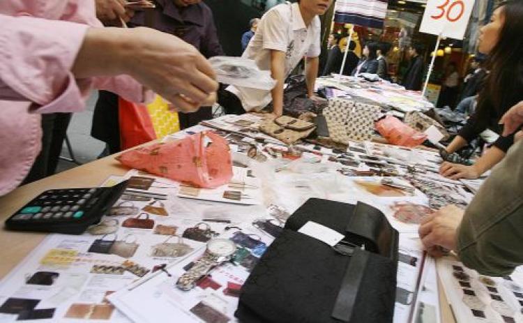 <a><img src="https://www.theepochtimes.com/assets/uploads/2015/09/78924398.jpg" alt="People look at photographs of counterfeit designer bags and watches at a market in the Mong Kok district of Hong Kong 28 November 2007. (Mike Clarke/AFP/Getty Images)" title="People look at photographs of counterfeit designer bags and watches at a market in the Mong Kok district of Hong Kong 28 November 2007. (Mike Clarke/AFP/Getty Images)" width="320" class="size-medium wp-image-1834155"/></a>
