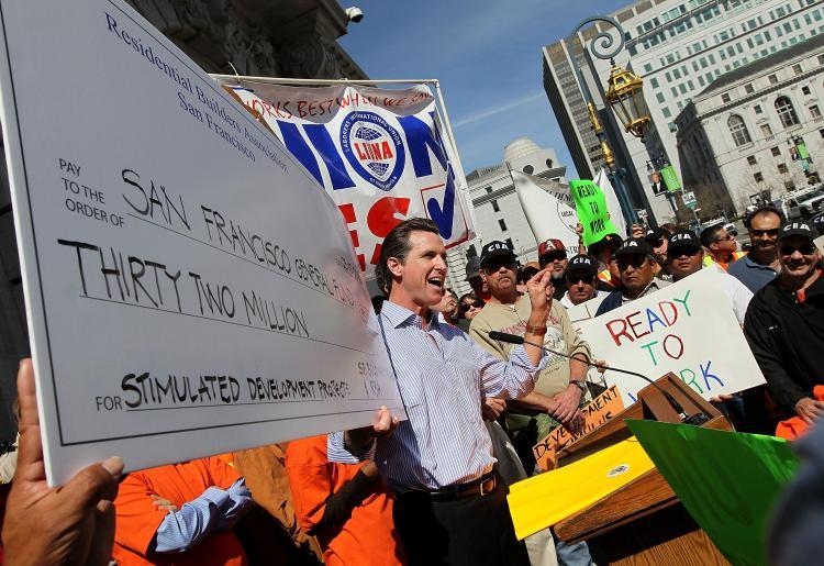 <a><img src="https://www.theepochtimes.com/assets/uploads/2015/09/97735614.jpg" alt="San Francisco Mayor Gavin Newsom holds a mock stimulus check as he speaks to union workers during a rally in support of a proposed stimulus reform package for the City of San Francisco March 15, 2010 in San Francisco, California. (Justin Sullivan/Getty Images)" title="San Francisco Mayor Gavin Newsom holds a mock stimulus check as he speaks to union workers during a rally in support of a proposed stimulus reform package for the City of San Francisco March 15, 2010 in San Francisco, California. (Justin Sullivan/Getty Images)" width="320" class="size-medium wp-image-1817363"/></a>