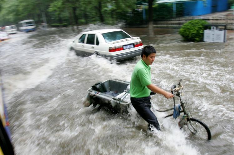 <a><img src="https://www.theepochtimes.com/assets/uploads/2015/09/BeijingRain_Crop82240483.jpg" alt="ALL WET: A man pushes a tricycle along a flooded road after heavy rain on August 10, 2008 in Beijing, China. (China Photos/Getty Images)" title="ALL WET: A man pushes a tricycle along a flooded road after heavy rain on August 10, 2008 in Beijing, China. (China Photos/Getty Images)" width="320" class="size-medium wp-image-1834363"/></a>