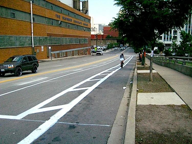 <a><img src="https://www.theepochtimes.com/assets/uploads/2015/09/Bike_protection_lanes_2.jpg" alt="Kinzie Street near Desplaines Street, an example of a bike lane protected by 4 feet of buffer area, and a lane for parking. (Courtesy of Chicago Department of Transportation)" title="Kinzie Street near Desplaines Street, an example of a bike lane protected by 4 feet of buffer area, and a lane for parking. (Courtesy of Chicago Department of Transportation)" width="575" class="size-medium wp-image-1802881"/></a>