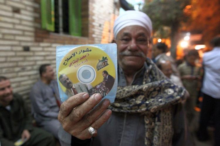 <a><img src="https://www.theepochtimes.com/assets/uploads/2015/09/EGYPT-107064329.jpg" alt="An Egyptian man holds a CD with information about the Muslim Brotherhood's member of Parliament and parliamentary candidate Mohammed al-Biltagi that was distributed during a campaign rally for the upcoming Egyptian general election in the village of Mit Nama, near Cairo, on Nov. 21. (Khaled Desouki/AFP/Getty Images)" title="An Egyptian man holds a CD with information about the Muslim Brotherhood's member of Parliament and parliamentary candidate Mohammed al-Biltagi that was distributed during a campaign rally for the upcoming Egyptian general election in the village of Mit Nama, near Cairo, on Nov. 21. (Khaled Desouki/AFP/Getty Images)" width="320" class="size-medium wp-image-1811796"/></a>