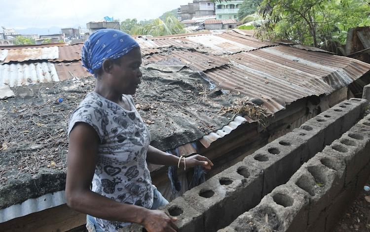 <a><img class="size-large wp-image-1774488" src="https://www.theepochtimes.com/assets/uploads/2015/09/Haiti_156146186.jpg" alt="A woman works on her house after recent floods in Vertieres, suburb of the city of Cap-Haitian, Haiti, on Nov. 11, 2012. (Thony Belizaire/AFP/Getty Images)" width="590" height="370"/></a>