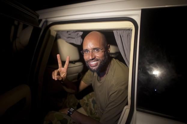 <a><img class="size-large wp-image-1787385" title="Saif al-Islam Kadhafi, son of former Libyan leader Moammar Gadhafi, flashes the V-sign for victory as he appears in front of supporters and journalists in the Libyan capital Tripoli in the early hours of August 23, 2011. (Dario Lopez-Mills/AFP/Getty Images)" src="https://www.theepochtimes.com/assets/uploads/2015/09/Saif124641837.jpg" alt="" width="590" height="393"/></a>