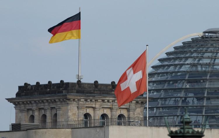 <a><img class="size-large wp-image-1781792" src="https://www.theepochtimes.com/assets/uploads/2015/09/SwissBank.jpg" alt="Swiss and German flags fly over the Swiss Embassy and the German Reichtsag behind it in Berlin, July 16. After German states purchased the names of German tax-evaders from Swiss bank employees, Germany and Switzerland reached a bilateral tax treaty, though it has yet to be ratified. (Sean Gallup/Getty Images)" width="590" height="374"/></a>
