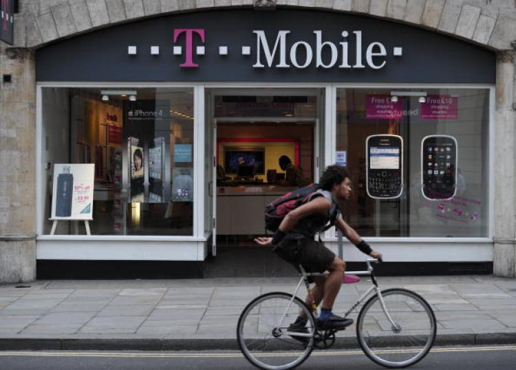 <a><img src="https://www.theepochtimes.com/assets/uploads/2015/09/Tmobile104565287.jpg" alt="A man cycles past a T-Mobile shop in Fleet Street, London, on September 30, 2010. Everything Everywhere, formed in the UK merger of T-mobile and Orange, is cutting 1,200 jobs to reduce duplication. (Carl Court/AFP/Getty Images)" title="A man cycles past a T-Mobile shop in Fleet Street, London, on September 30, 2010. Everything Everywhere, formed in the UK merger of T-mobile and Orange, is cutting 1,200 jobs to reduce duplication. (Carl Court/AFP/Getty Images)" width="320" class="size-medium wp-image-1806584"/></a>