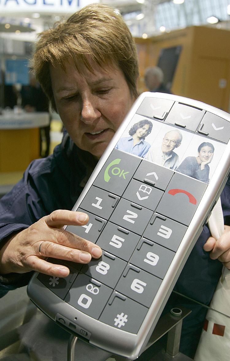 <a><img src="https://www.theepochtimes.com/assets/uploads/2015/09/braillephone73625340.jpg" alt="A woman inspects the mockup of a mobile phone with oversized Braille-marked keys. (Nigel Treblin/AFP/Getty Images)" title="A woman inspects the mockup of a mobile phone with oversized Braille-marked keys. (Nigel Treblin/AFP/Getty Images)" width="320" class="size-medium wp-image-1813637"/></a>