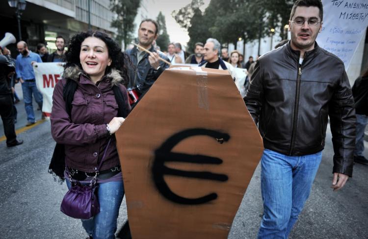 <a><img src="https://www.theepochtimes.com/assets/uploads/2015/09/euro_protest.jpg" alt="Protesters carry a cardboard-made coffin with an Euro symbol on it in Athens last month. (Louisa Gouliamaki/AFP/Getty Images)" title="Protesters carry a cardboard-made coffin with an Euro symbol on it in Athens last month. (Louisa Gouliamaki/AFP/Getty Images)" width="320" class="size-medium wp-image-1821212"/></a>