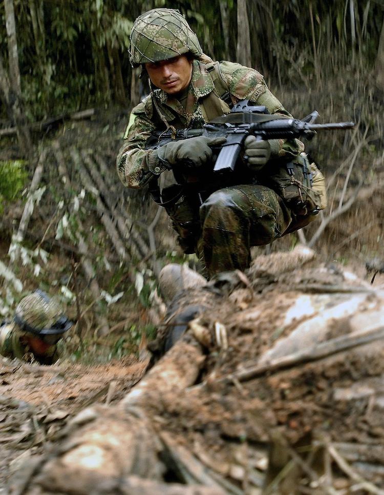<a><img class="size-large wp-image-1788207" title="A Colombian soldier stares at the body of a member of the Revolutionary Armed Forces of Colombia (FARC), in a rural zone in Puerto Rico, Meta department, in Colombia, on July 25, 2009. (Luis Ramirez/AFP/GettyImages)" src="https://www.theepochtimes.com/assets/uploads/2015/09/farc143566043.jpg" alt="" width="362" height="466"/></a>