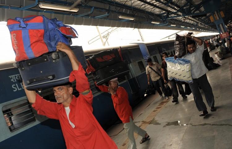 <a><img class="size-large wp-image-1768781" title="Indian porters and passengers carry luggage at the New Delhi railway station. Railway porters operate in India under licenses issued by the authorities. The profession is largely dominated by men. (Manan Vatsyayana/AFP/Getty Images)" src="https://www.theepochtimes.com/assets/uploads/2015/09/porter.jpg" alt="" width="590" height="378"/></a>