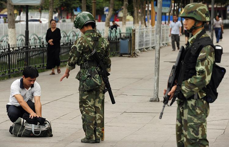 <a><img src="https://www.theepochtimes.com/assets/uploads/2015/09/ruun89015395.jpg" alt="Chinese paramilitary policemen search a man's bag on a street in the Uighur district of Urumqi city, in China's Xinjiang region on July 14, 2009. (Peter Parks/AFP/Getty Images)" title="Chinese paramilitary policemen search a man's bag on a street in the Uighur district of Urumqi city, in China's Xinjiang region on July 14, 2009. (Peter Parks/AFP/Getty Images)" width="320" class="size-medium wp-image-1827376"/></a>