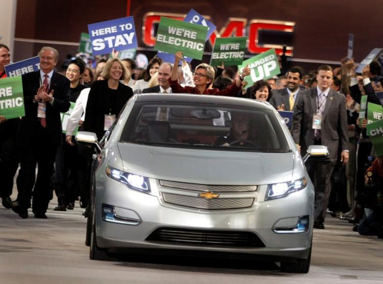 <a><img src="https://www.theepochtimes.com/assets/uploads/2015/09/volt_lowres.jpg" alt="LEANER AND GREENER: Michigan Gov. Jennifer Granholm (red dress) marches with auto workers and dignitaries behind a Chevy Volt electric vehicle during the introduction of General Motors' vehicles during the press preview for the Detroit International Auto  (Bill Pugliano/Getty Images)" title="LEANER AND GREENER: Michigan Gov. Jennifer Granholm (red dress) marches with auto workers and dignitaries behind a Chevy Volt electric vehicle during the introduction of General Motors' vehicles during the press preview for the Detroit International Auto  (Bill Pugliano/Getty Images)" width="320" class="size-medium wp-image-1831408"/></a>