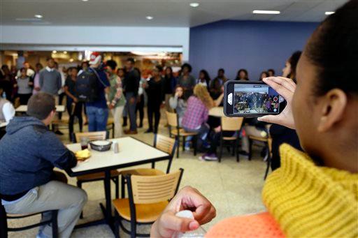 In this Saturday, Nov. 7, 2015, photo, a member of Concerned Student 1950 films a protest in Mark Twain Dining Hall on University of Missouri campus, in Columbia, Mo. (Sarah Bell/Missourian via AP)